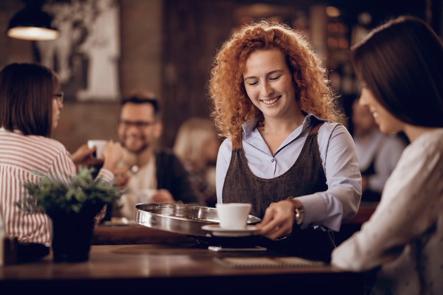 A cafe owner mid-service on a busy Saturday